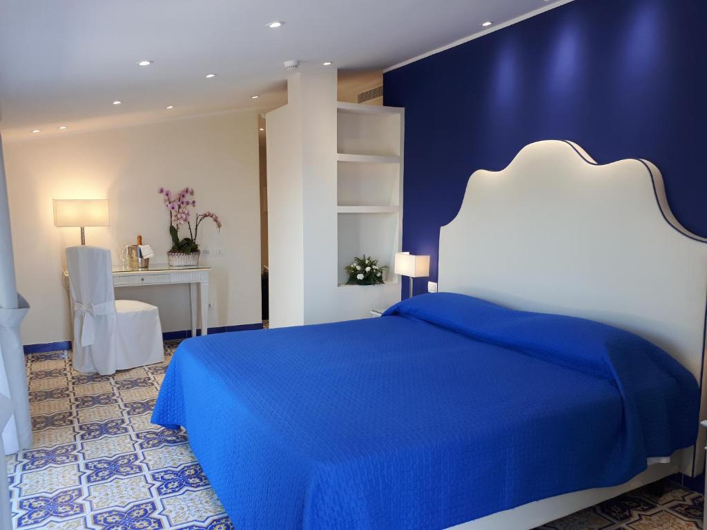 niebiesko-biała sypialnia z łóżkiem i biurkiem w obiekcie Hotel La Vue d'Or w Sorrento