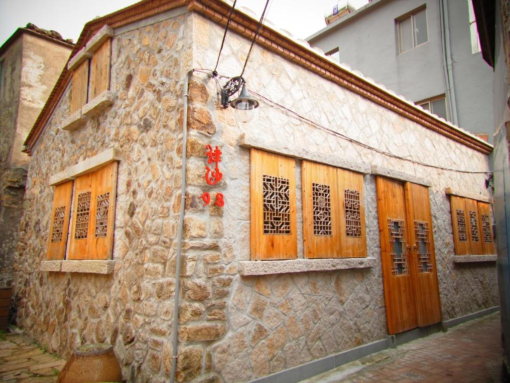 沐光獨棟館 في نانجان: مبنى حجري قديم مع نوافذ خشبية مقفلة