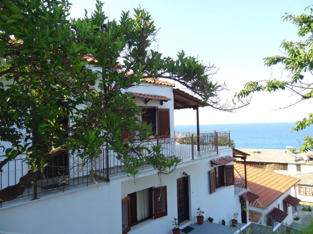 a building with a balcony and the ocean in the background at Germanis House in Agios Ioannis Pelio