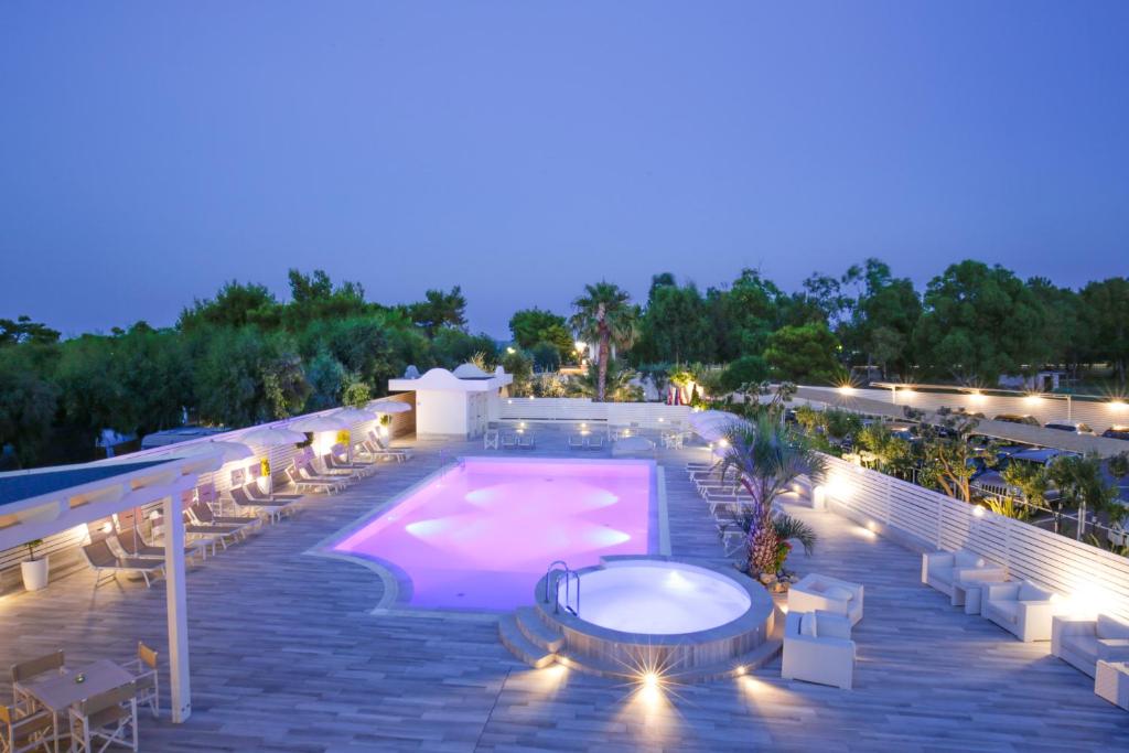 ein großer Pool auf einer Terrasse in der Nacht in der Unterkunft Garden Hotel Ripa in Vieste