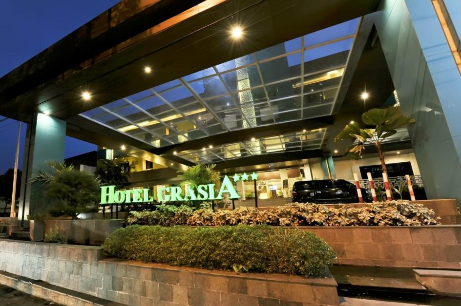 un hotel con un cartel frente a un edificio en Hotel Grasia en Semarang