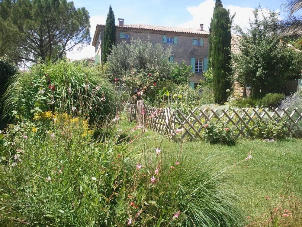 einen Garten vor einem Haus mit einem Zaun in der Unterkunft La Bastide de Boisset in Argilliers