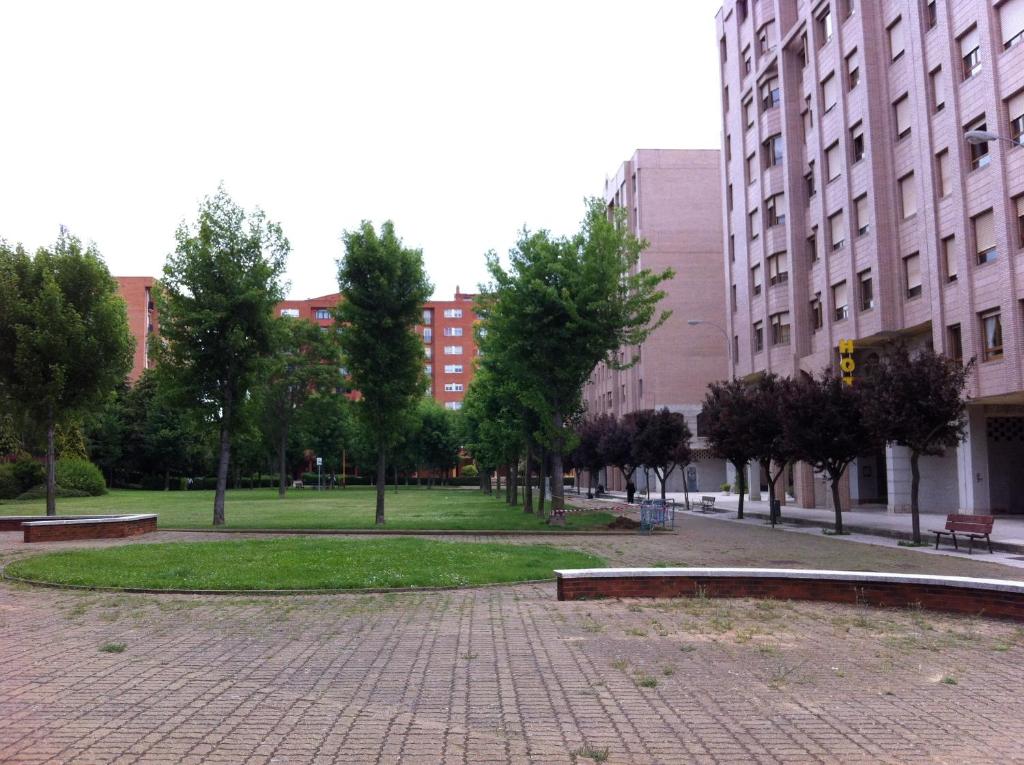 un parque con árboles y edificios en una ciudad en Apartahotel Siglo XXI, en León