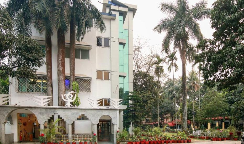 a building with palm trees in front of it at Sher-E-Punjab in Kolkata