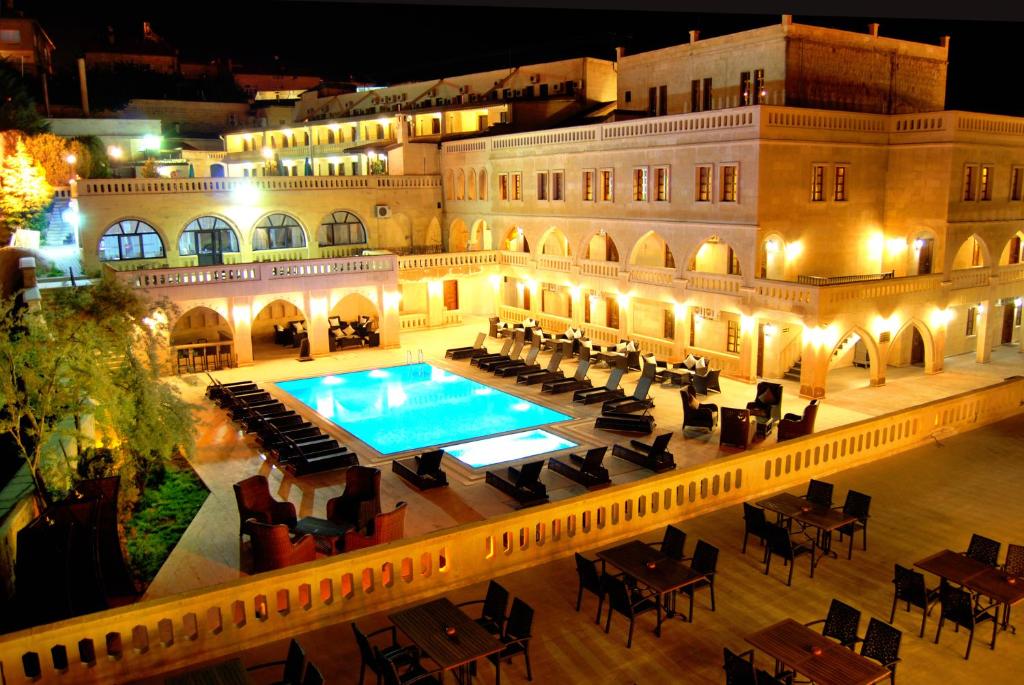 a large building with a swimming pool in front of it at Dilek Kaya Hotel in Ortahisar