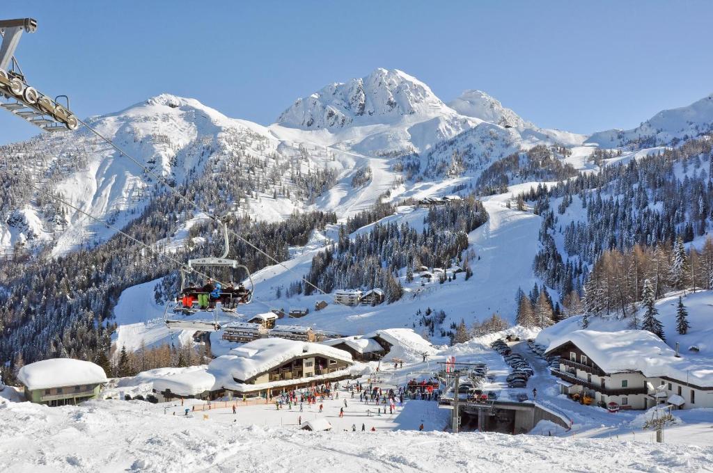 ein Skigebiet auf einem verschneiten Berg mit Skilift in der Unterkunft Sölle Homes Nassfeld in Sonnenalpe Nassfeld