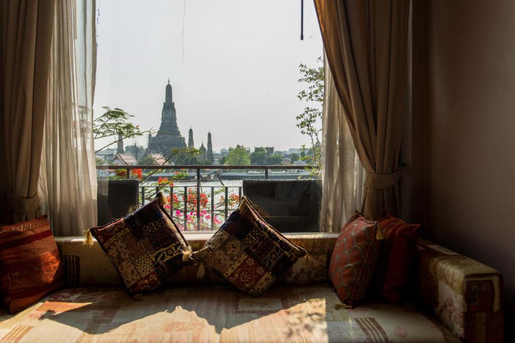 سالا أرون في بانكوك: أريكة مع وسائد موضوعة أمام النافذة