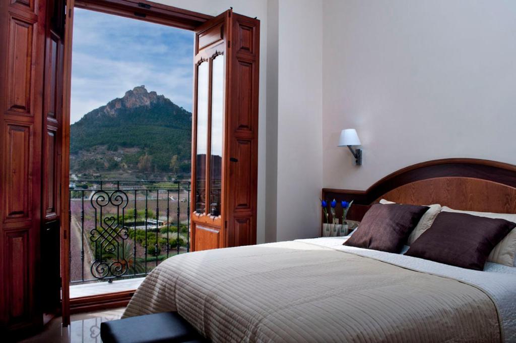 1 dormitorio con cama y vistas a la montaña en Hotel San Sebastián Hospedería, en Cieza