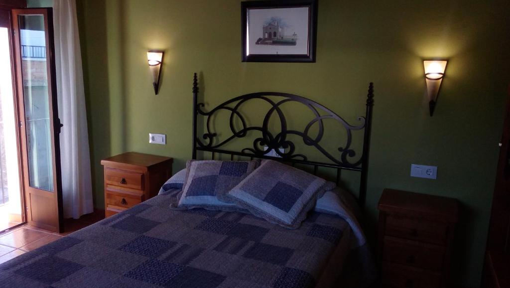 1 dormitorio con 1 cama en una habitación verde en Apartamentos Rurales Casas de los Maestros, en Talarrubias