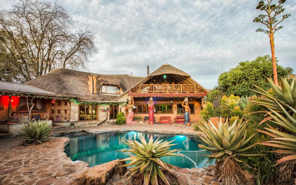 a house with a swimming pool in front of it at Amphitheatre Backpackers Lodge in Ethels Drive