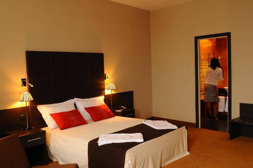 a woman standing in a hotel room with a bed at TANA Hotel in Antananarivo