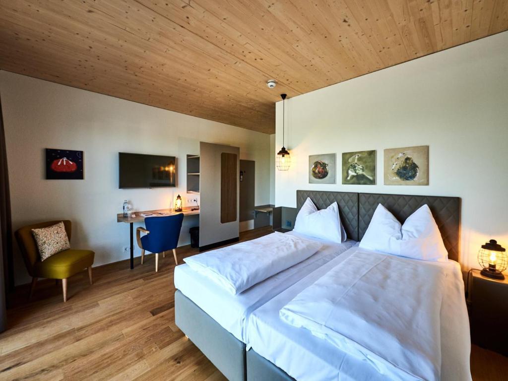 Schlafzimmer mit einem großen weißen Bett und einem Schreibtisch in der Unterkunft Hotel Katamaran in Rust