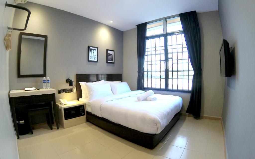 a bedroom with a large bed and a window at JV Hotel @ Simpang Ampat in Simpang Ampat