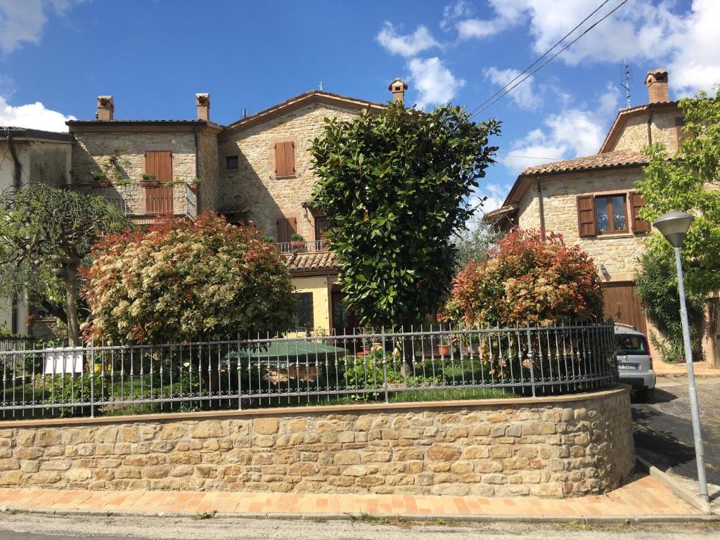 uma casa com uma cerca em frente em Appartamenti e Camere Il Poggio di D'Angeli Lidia em Auditore