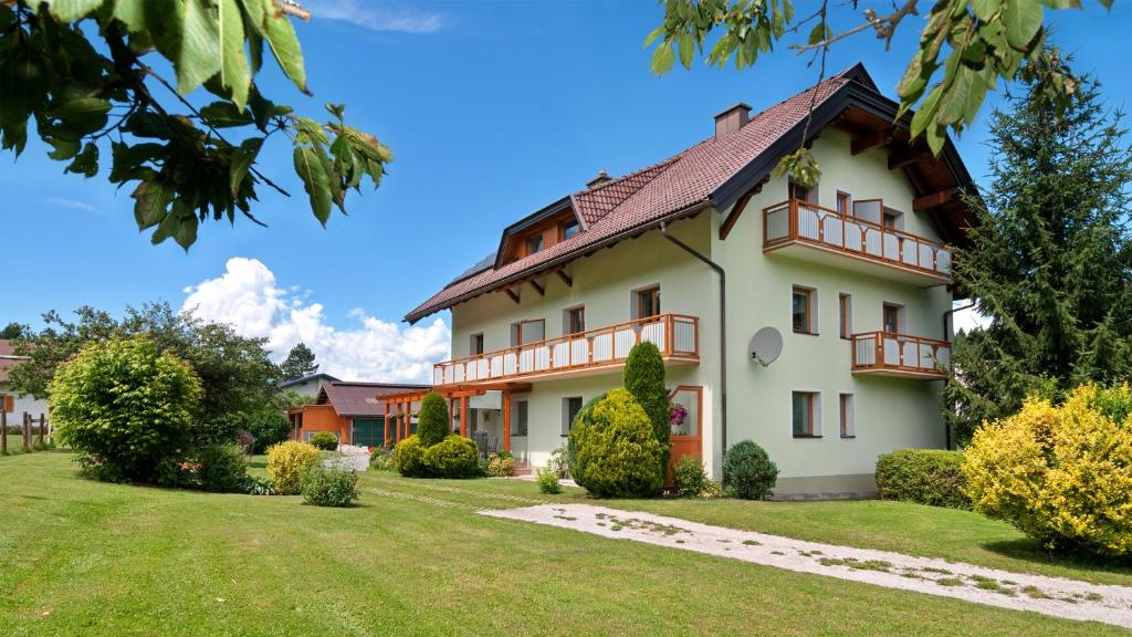 a large white house with a yard at Gästehaus Temitzhof in Latschach