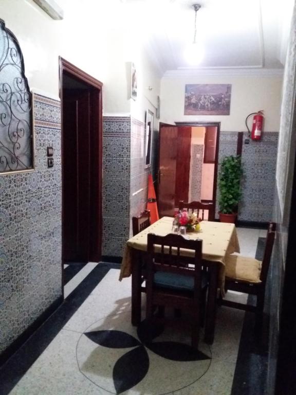 - une salle à manger avec une table et des chaises en bois dans l'établissement La Perle, à Meknès