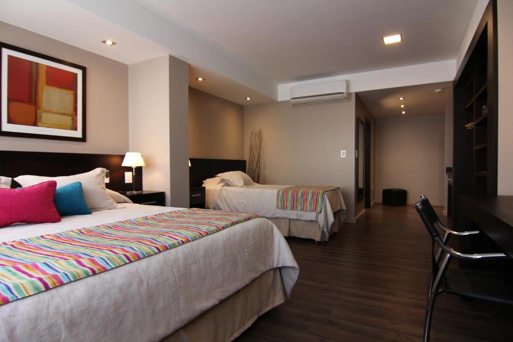 a hotel room with two beds and a tv at 646 Hotel Balcarce in Balcarce