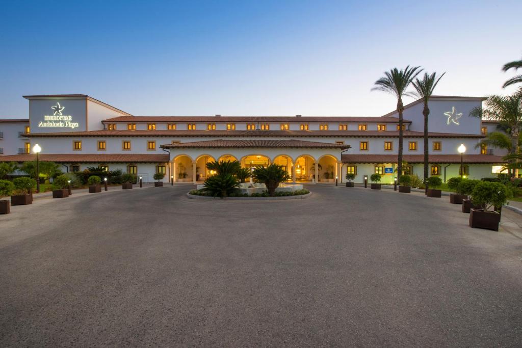 a large building with a courtyard at dusk at Iberostar Selection Andalucia Playa in Chiclana de la Frontera