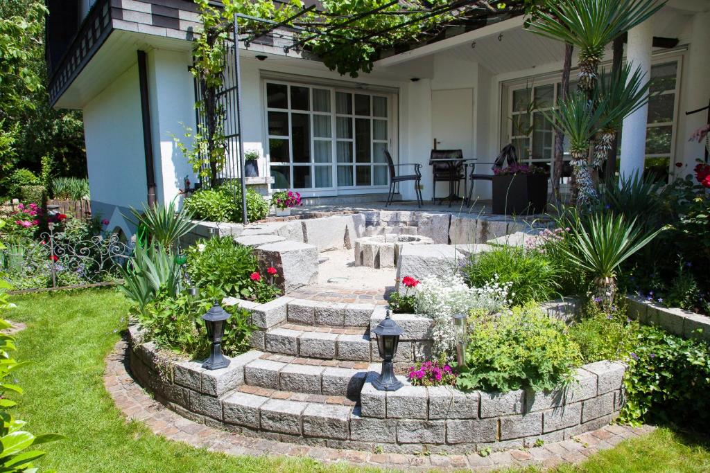 a garden with flowers and stairs in front of a house at Ferienwohnung Fessler in Weil am Rhein