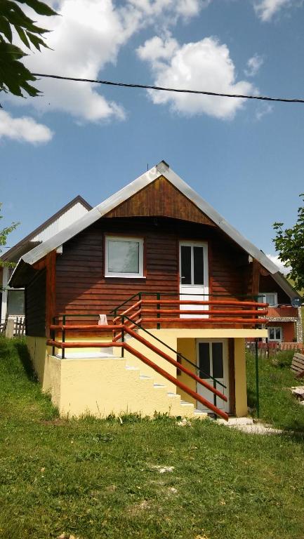 een klein huis met een veranda en een trap bij Apartman Andrija in Žabljak