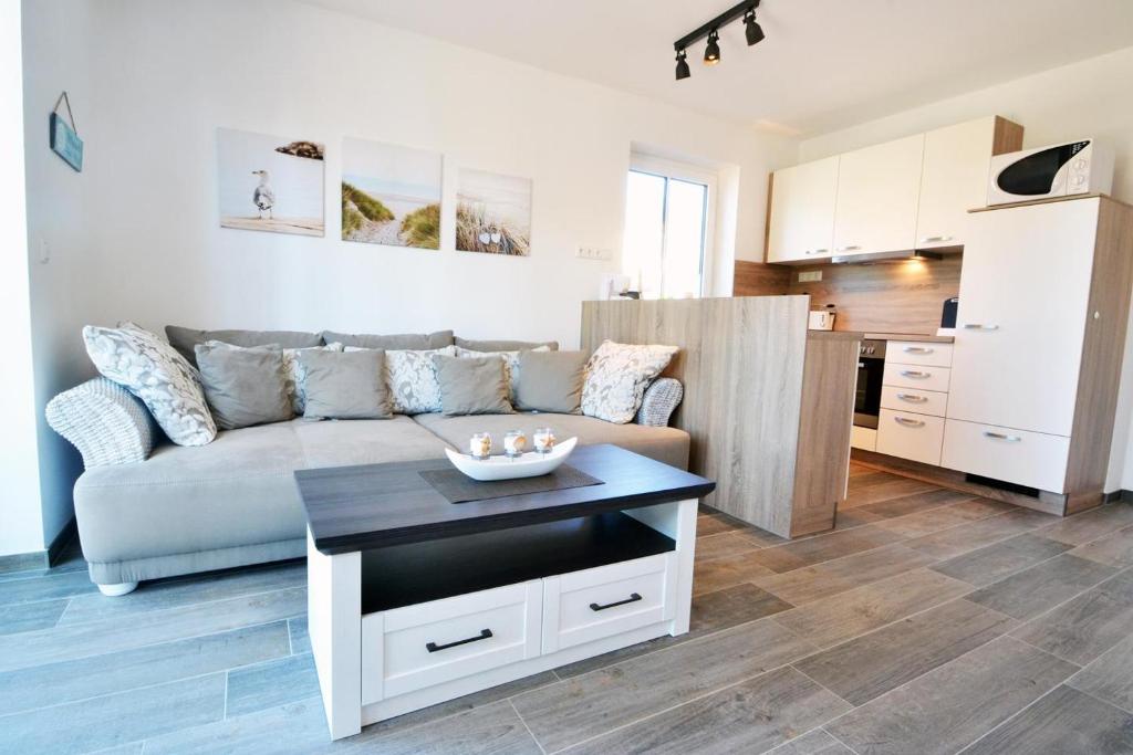 uma sala de estar com um sofá e uma cozinha em Waldsiedlung DHH MeerSeenSucht em Korswandt
