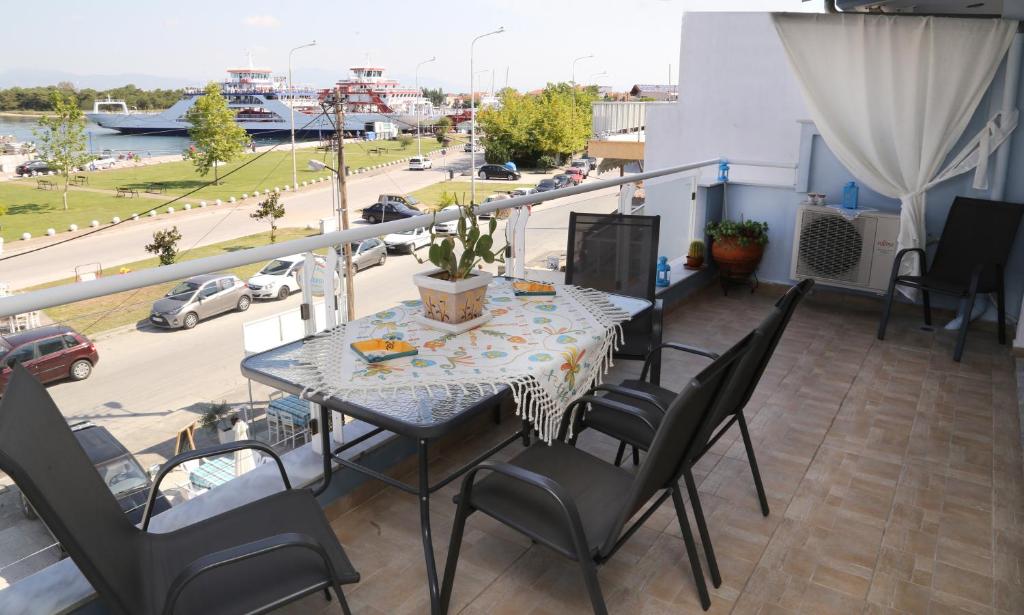 stół i krzesła na balkonie z widokiem na ulicę w obiekcie Athina Luxury Apartment w mieście Keramotí