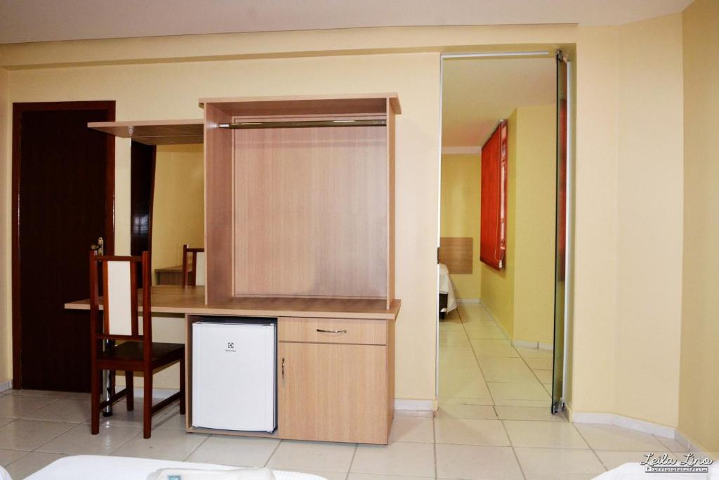 a kitchen with a counter and a table and a chair at Ana Maria Apart Hotel in Arcos