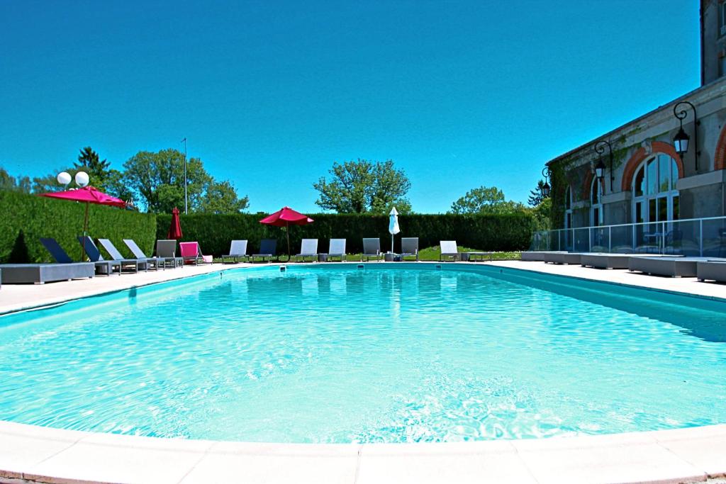 une grande piscine en face d'un bâtiment dans l'établissement Hôtel Cosmos & Spa, à Contrexéville