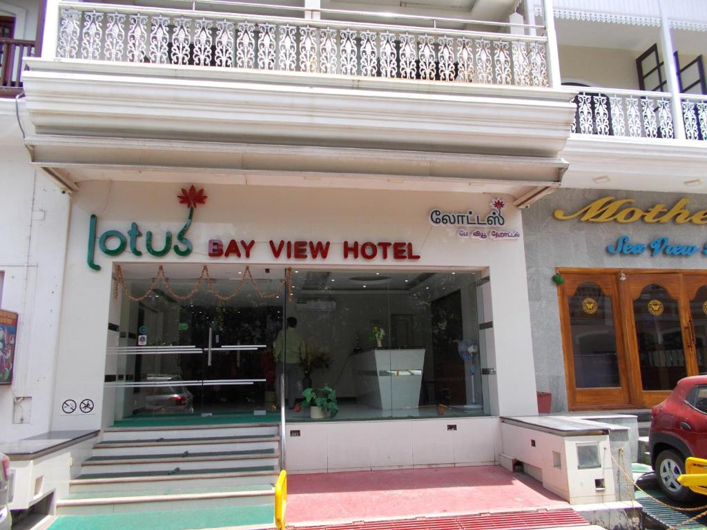 uma frente de loja com um cartaz que lê leões diz hotel view em Lotus Bay View Hotel em Pondicherry