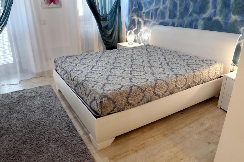 uma cama branca num quarto com uma parede azul em Affittacamere Massimo D'Azeglio em Barletta