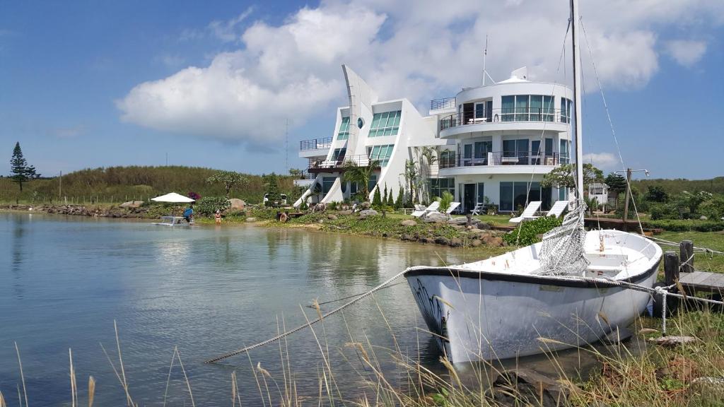 白沙鄉的住宿－澎湖候鳥潮間帶民宿，一艘船停靠在一座大建筑前面