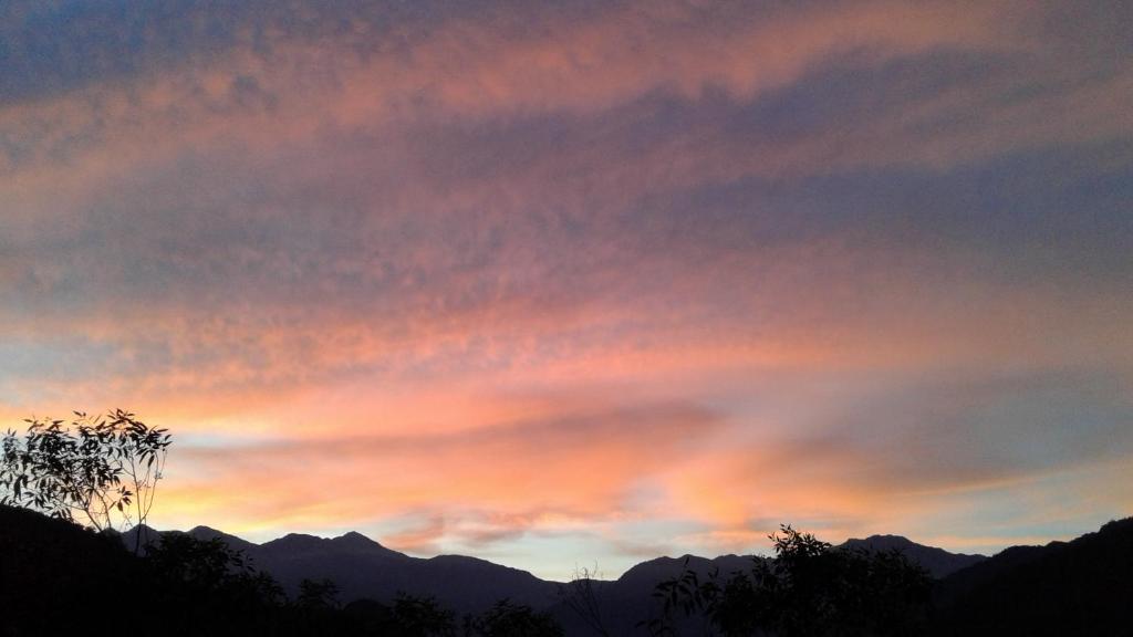 a sunset sky with mountains in the background at Ti Siang B&amp;B in Ren&#39;ai
