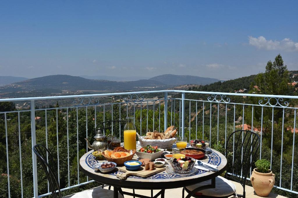 a table with food on top of a balcony at Zimmers at the Forest in Amirim