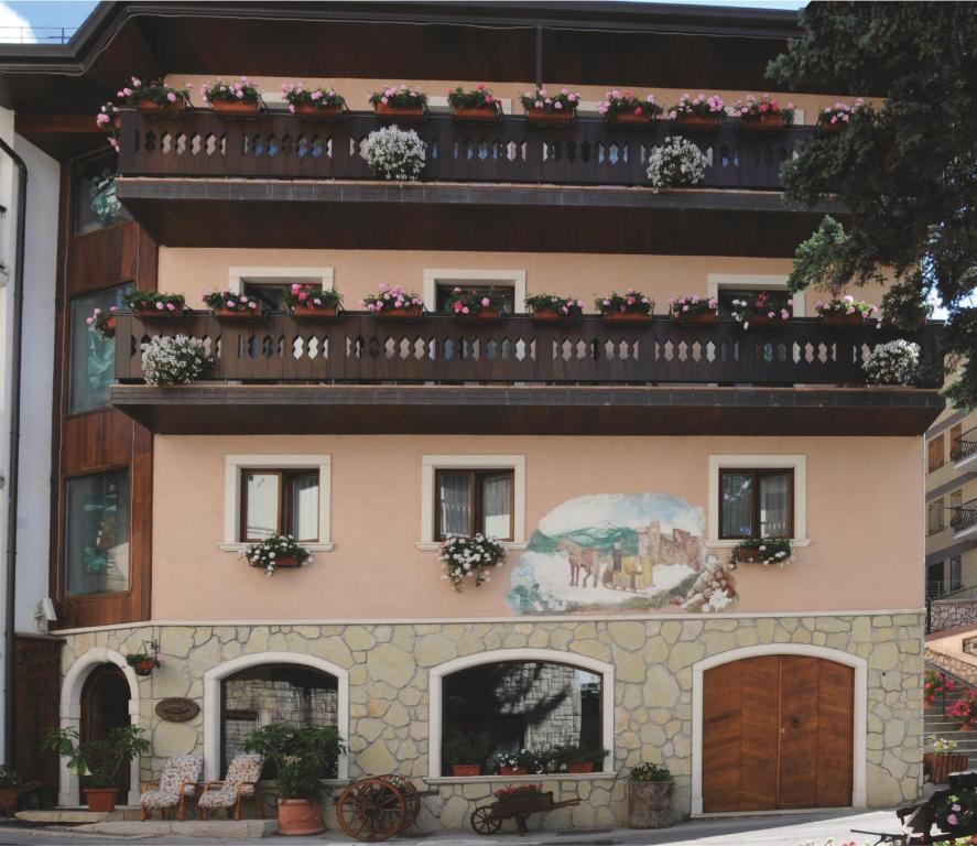 ein Gebäude mit einem Balkon mit Blumen darauf in der Unterkunft Hotel Lo Scoiattolo in Roccaraso