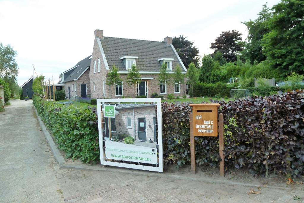 a sign in front of a house with a window at Bed&Breakfast Hoornaar in Hoornaar