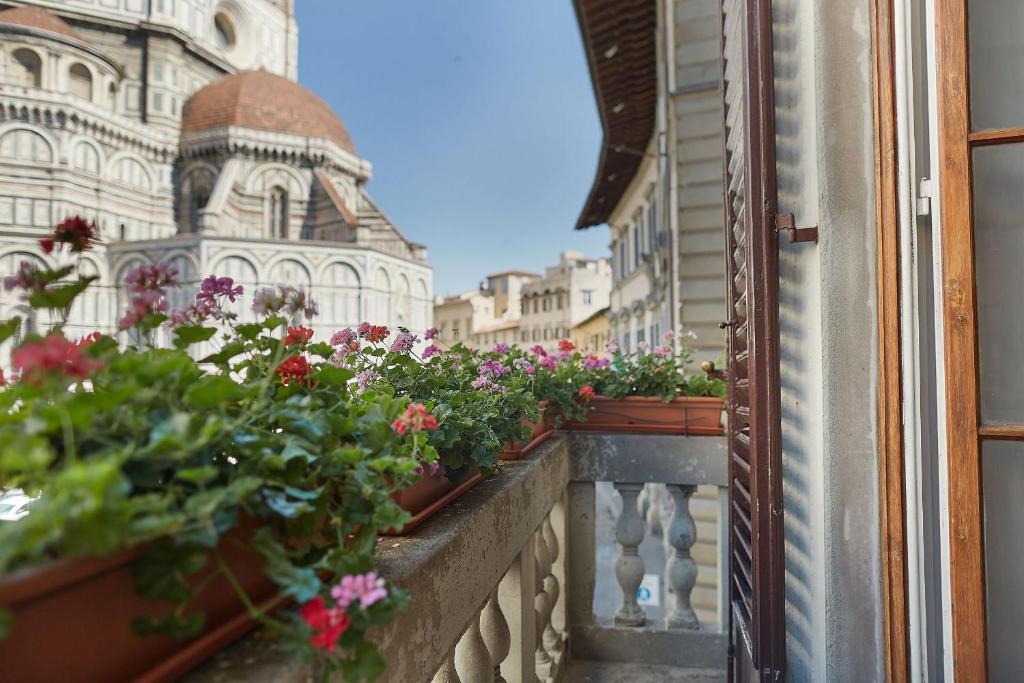 a balcony with potted flowers and a building at B&B Di Piazza Del Duomo in Florence