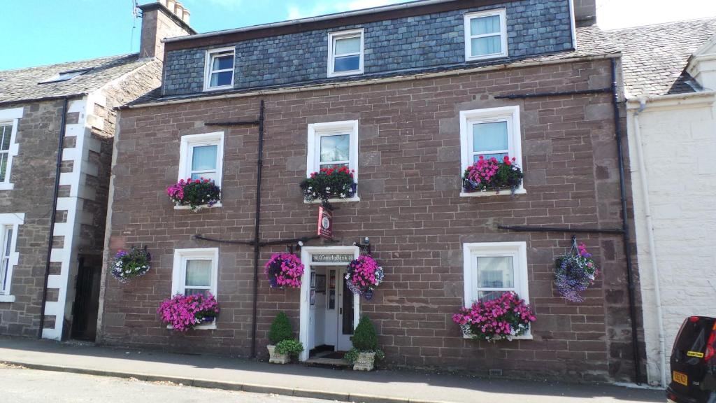 a brick house with flowers in the window boxes at Comelybank Guesthouse in Crieff