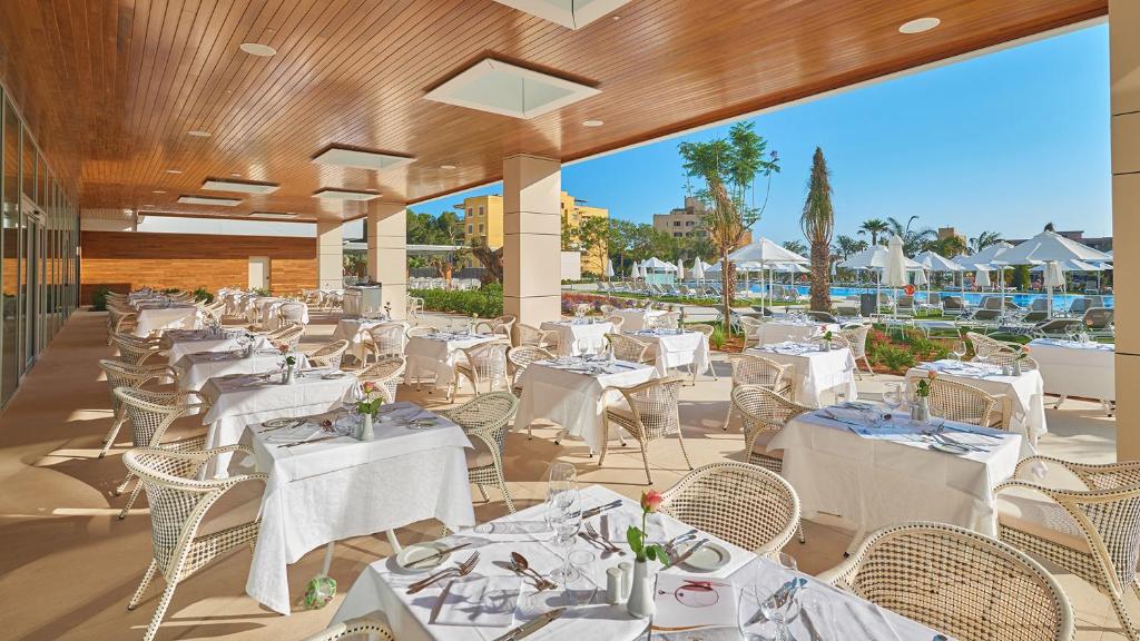 a restaurant with white tables and chairs on a patio at Hipotels Playa de Palma Palace&Spa in Playa de Palma