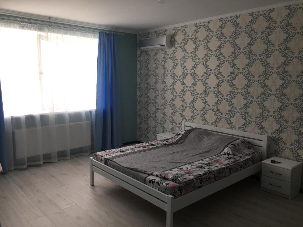 een kleine slaapkamer met een bed en een raam bij Apartment on Parkovaya in Chornomorsk