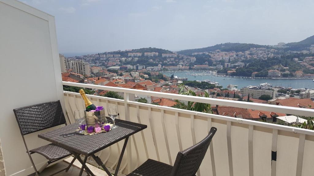 einen Tisch und Stühle auf einem Balkon mit Aussicht in der Unterkunft Guesthouse Perica in Dubrovnik