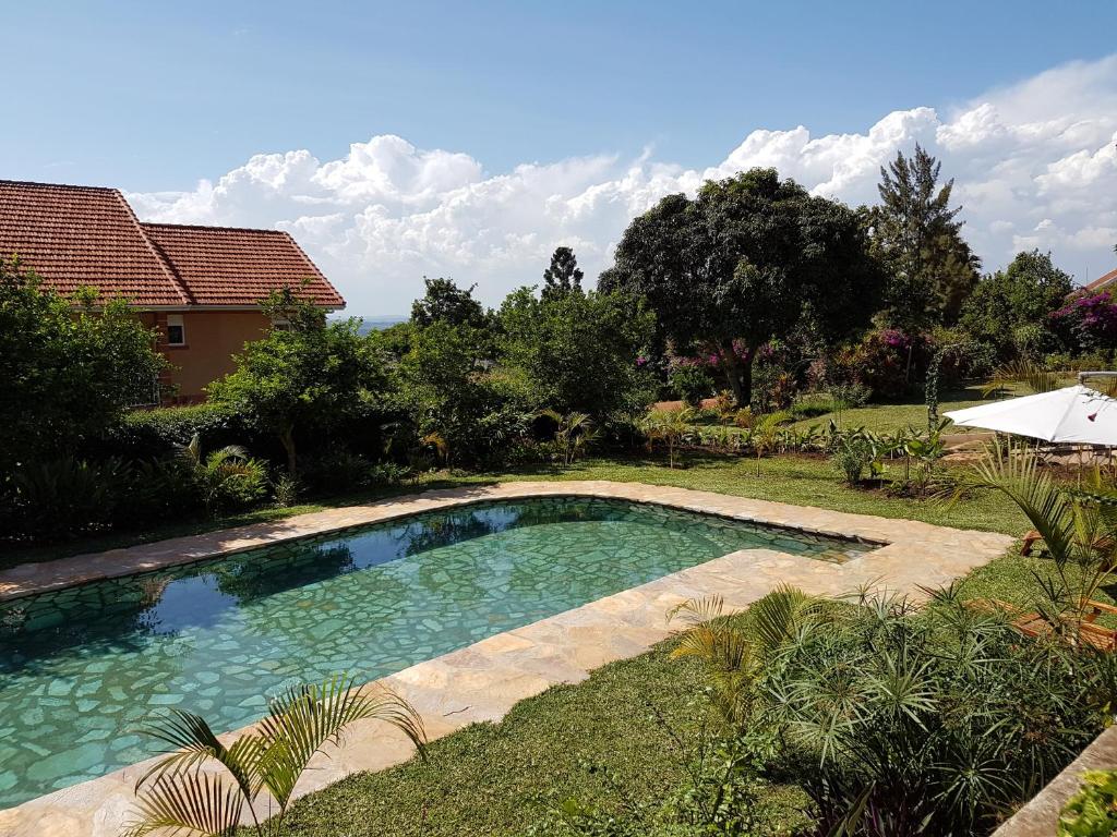 a swimming pool in the yard of a house at Pineapple Guest House Entebbe in Entebbe