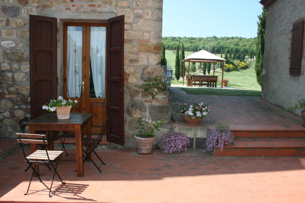 a patio with a table and chairs next to a building at Agriturismo Escaia in Volterra