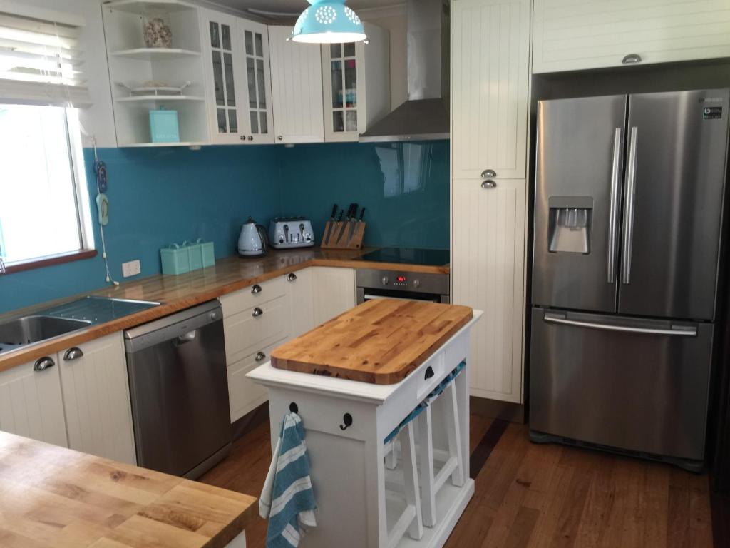 a kitchen with a refrigerator and a table in it at Aqua Shack Jurien Bay in Jurien Bay