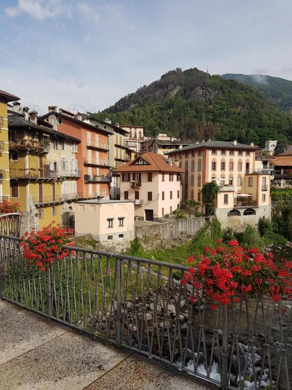 miasto z budynkami i czerwonymi kwiatami na balkonie w obiekcie residenza la roggia w mieście Varallo