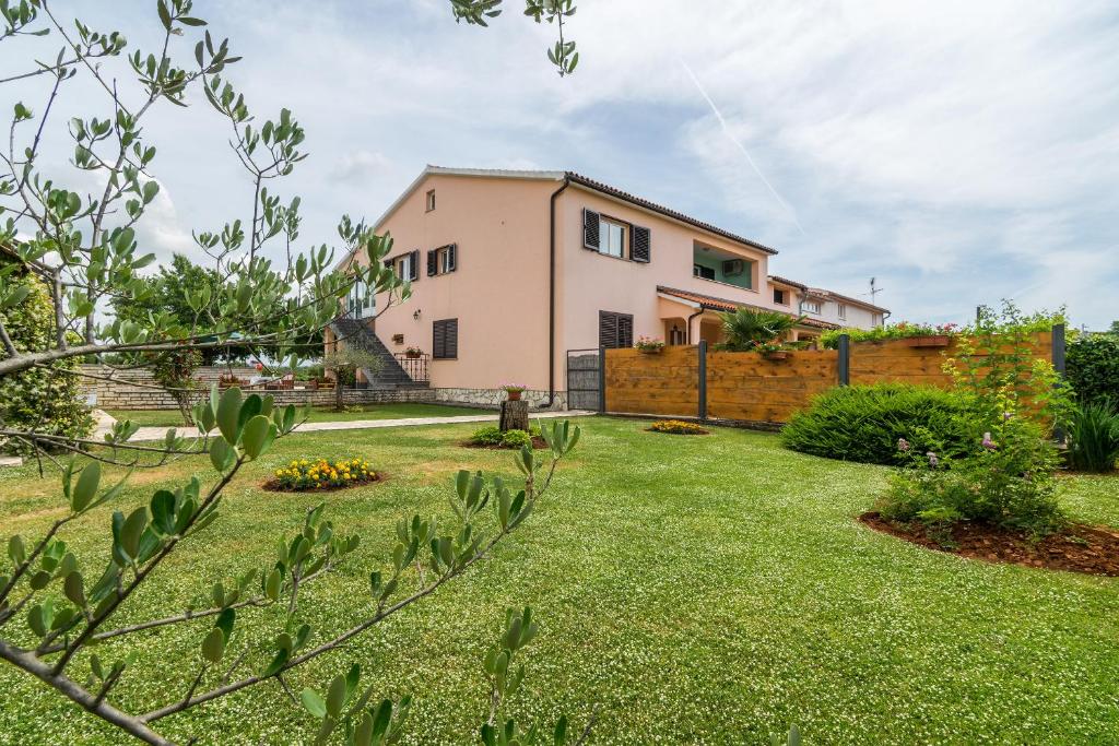 a house with a yard with a fence at Apartments Korina in Kanfanar