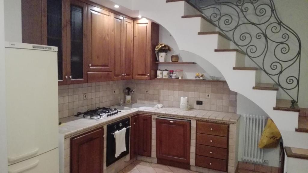 una cocina con armarios de madera y una escalera de caracol en casa bijoux, en Itri