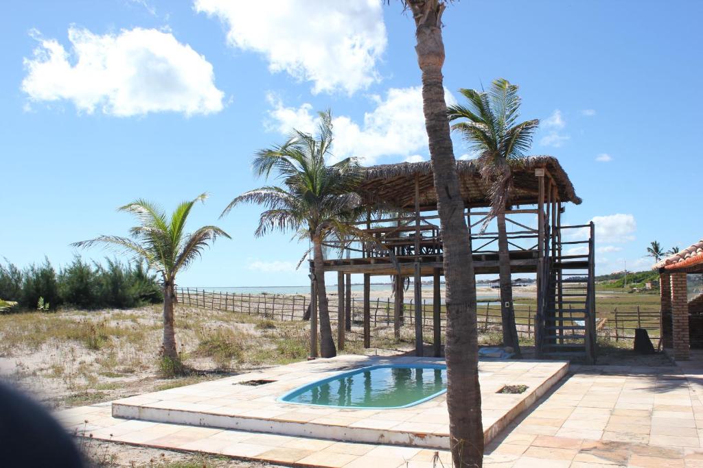 a resort with a swimming pool and palm trees at Casa de Praia Litoral Piauí in Luis Correia