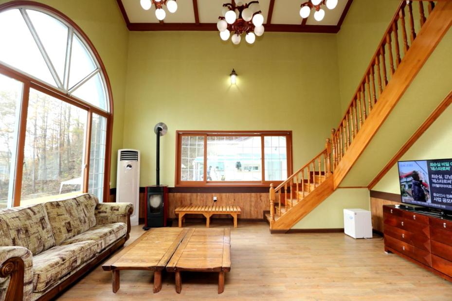 uma sala de estar com um sofá e uma mesa de centro em Pinearoma Pension em Hongcheon