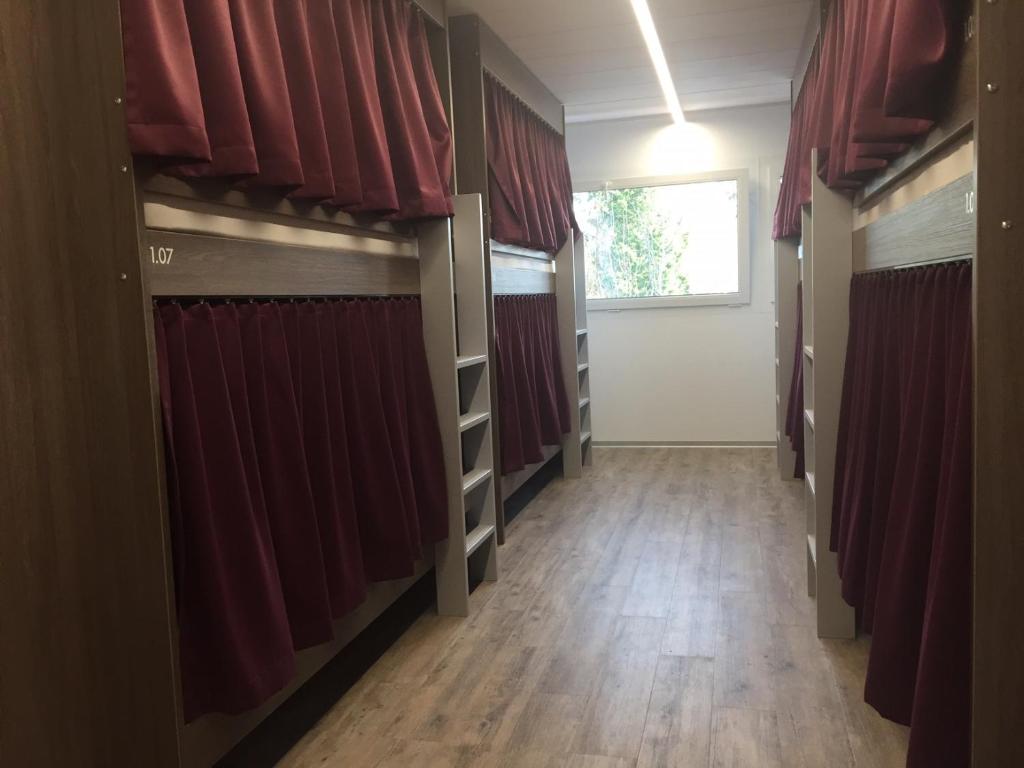 a long hallway with red curtains and a window at Auberge du Guintzet in Fribourg