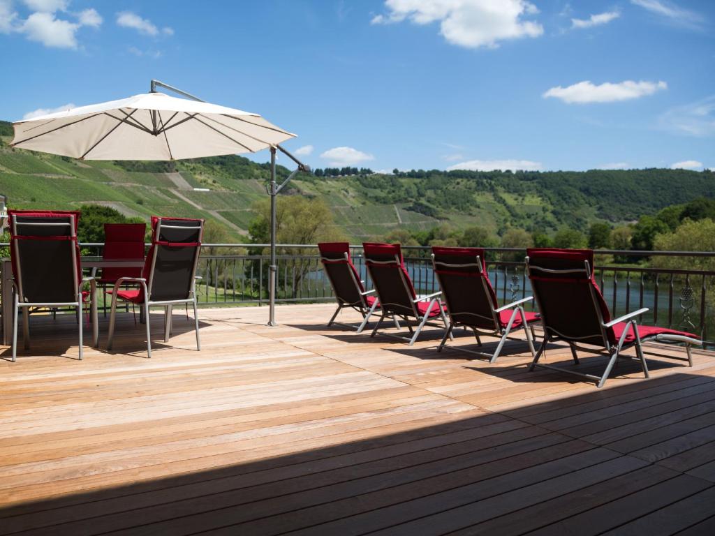 a group of chairs and an umbrella on a deck at Ferienwohnung Sonnendeck in Kröv